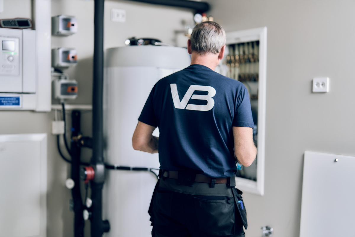Rørlegger i teknisk rom med varmtvannsbereder