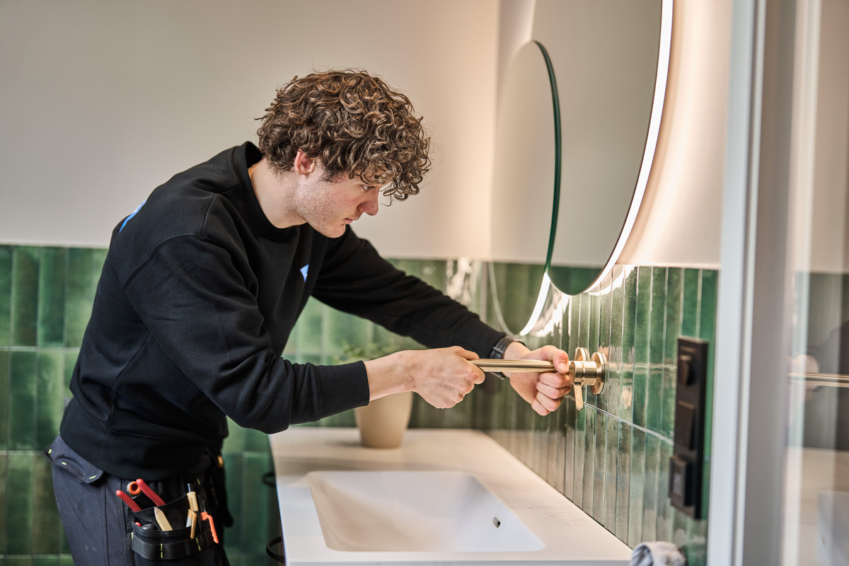 Rørlegger monterer veggmontert servantbatteri